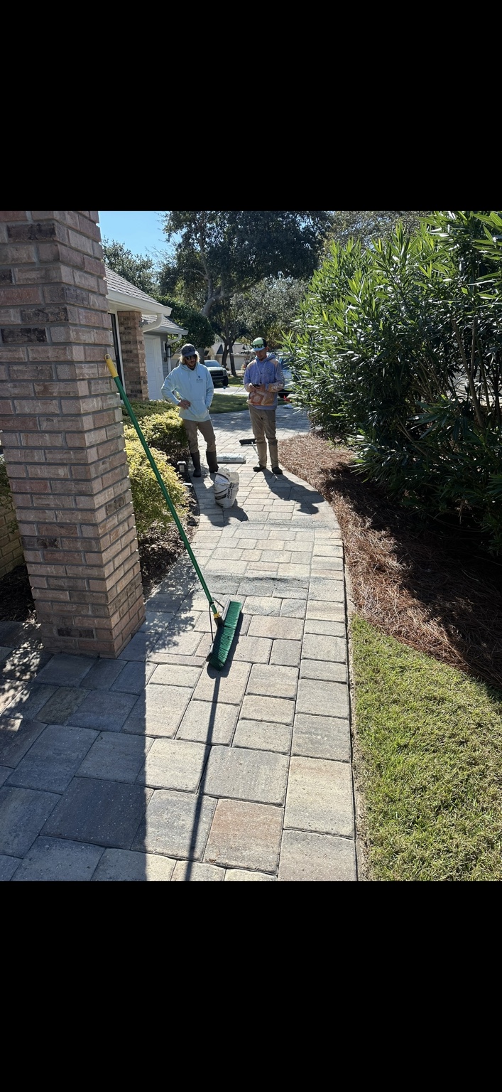 Optimum crew preparing and inspecting joint sand on residential pavers