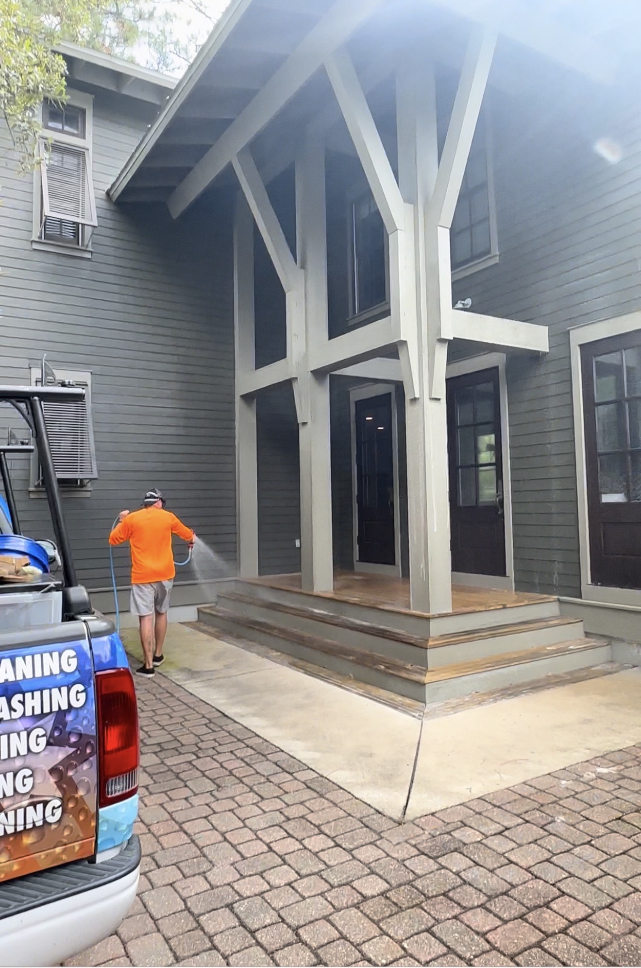 Optimum technician applying a low-pressure soft wash to a home