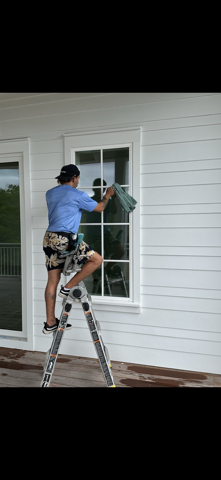 Optimum technician traditionally cleaning a residential window by hand